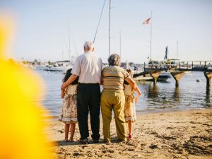 Grandparents standing with grandchildren on the beach 