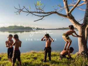 Children playing with each other by a serene lake 